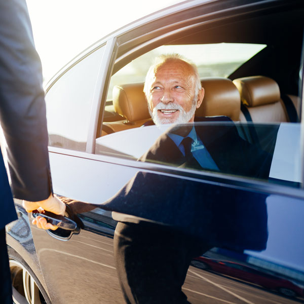 Senior business man sitting in his limousine. Business concept.