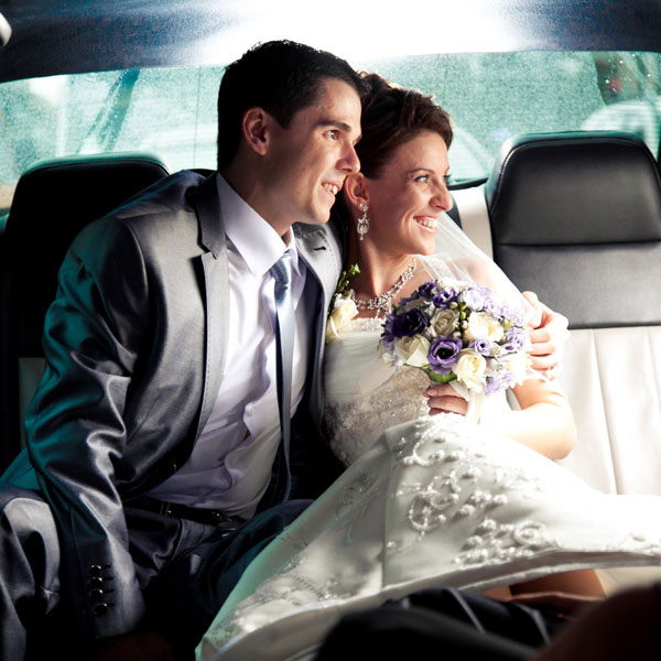 Couple sitting on backseat of the car and looking out of window