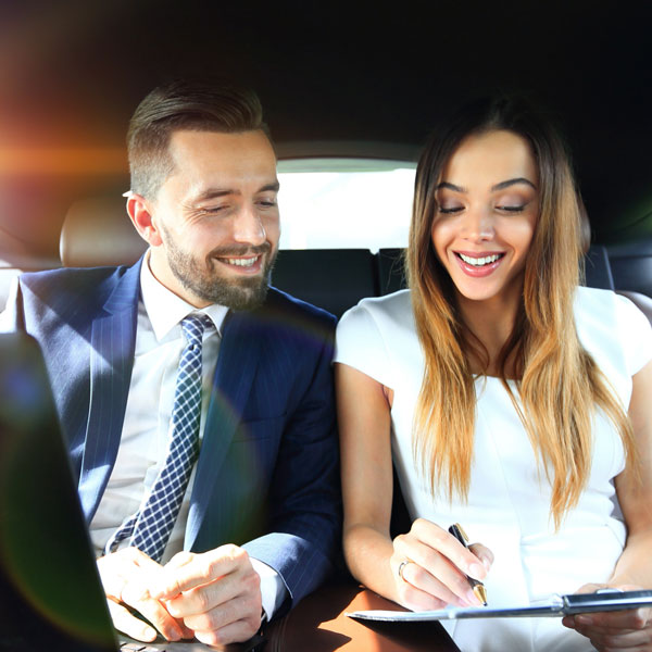 Man and woman discussing work documents in taxi